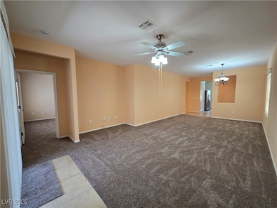 Spare room featuring carpet floors, a ceiling fan,
