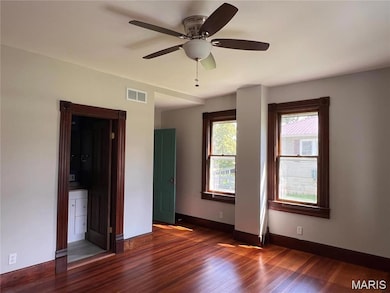 Unfurnished room with dark wood finished floors and ceiling fan