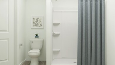 Bathroom with a stall shower and wood finished floors
