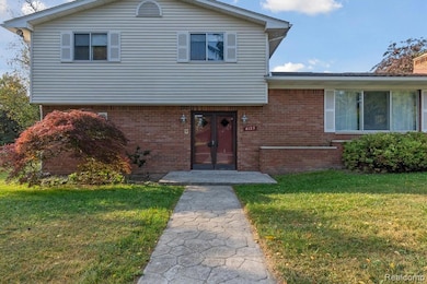 Split level home featuring brick siding and a front yard