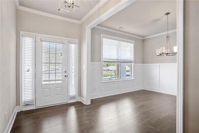 Entrance foyer with crown molding, a chandelier, a