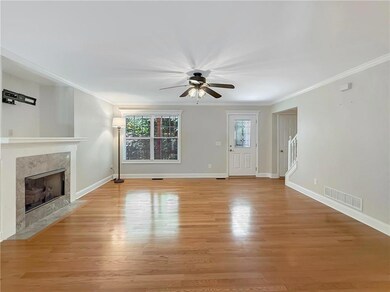 Unfurnished living room with light wood-style floors, a fireplace, ornamental molding, and ceiling fan