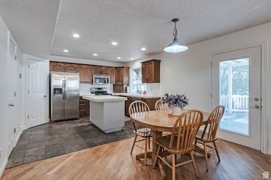 Dining space with dark wood-style floors, recessed lighting, and a textured ceiling