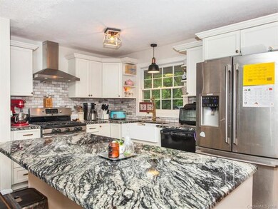New kitchen with crisp white cabinetry and granite