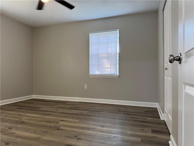 Spare room with dark wood finished floors and a ceiling fan