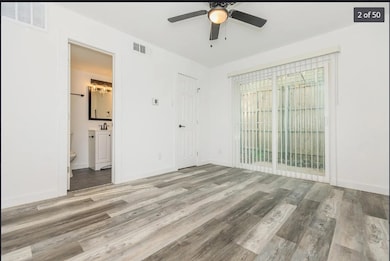 Unfurnished bedroom with wood finished floors, visible vents, and baseboards