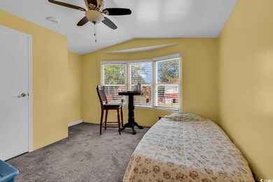 Bedroom featuring carpet flooring, lofted ceiling, and a ceiling fan