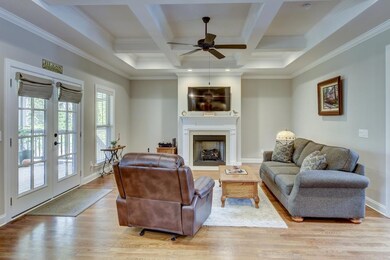 Living room with coffered ceilings, recessed lighting, instant start fireplace. French doors lead to new screened-in porch.  Never miss family time or entertaining guests. **Owner installed custom cabinets on each side of fireplace since this photo**