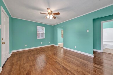 Unfurnished room with a ceiling fan, ornamental molding, and wood finished floors