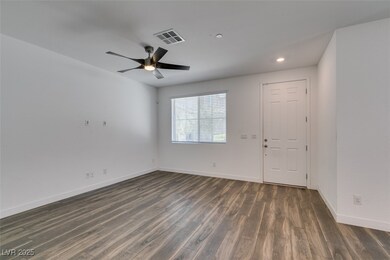 Empty room featuring dark wood-style flooring, visible vents, baseboards, ceiling fan, and recessed lighting