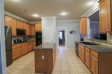 Kitchen featuring visible vents, a sink, crown mo