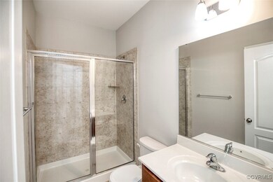 Bathroom featuring vanity, walk in shower, and toi