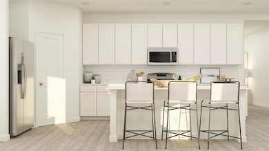 Kitchen featuring white microwave, white cabinetry