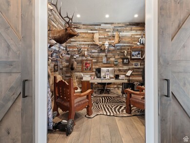 Office with wood-type flooring, recessed lighting, and wooden walls