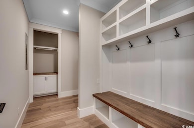 Mudroom featuring light wood finished floors, base