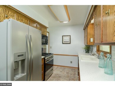 Kitchen features updated appliances and quartz cou