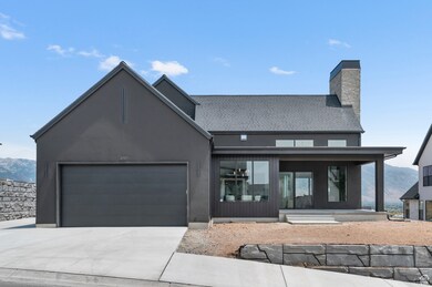 View of front of house featuring driveway, an attached garage, stucco siding, a chimney, and a mountain view