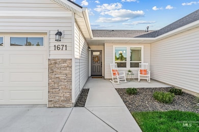 View of exterior entry featuring stone siding and roof with shingles
