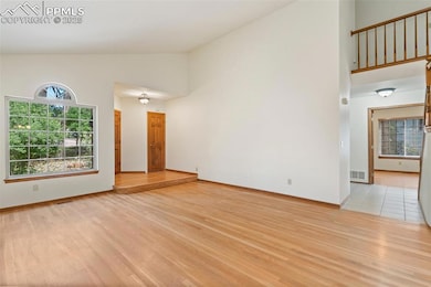 Unfurnished room with high vaulted ceiling and light wood-style flooring