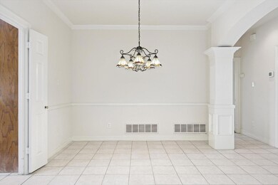 Large tiled formal dining area with decorative col