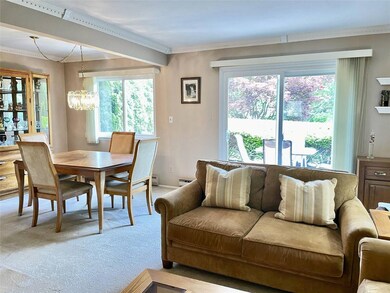 Dining space with light carpet, a chandelier, crown molding, and a baseboard radiator