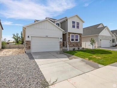 Craftsman inspired home featuring board and batten siding, stone siding, and driveway