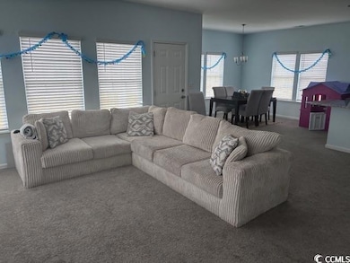 Living room with carpet flooring and a chandelier