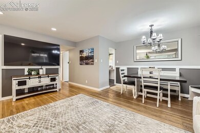 Dining room featuring natural wood floors and a chandelier.