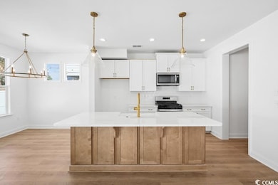 Kitchen featuring visible vents, white cabinetry, 