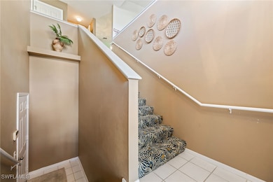 Stairs with tile patterned floors and baseboards