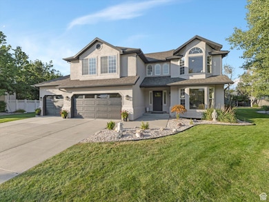 View of front of property with stucco siding, a garage, covered porch, driveway, and roof with shingles