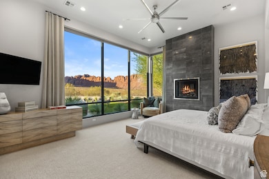 Bedroom with carpet floors, recessed lighting, a tile fireplace, and a ceiling fan