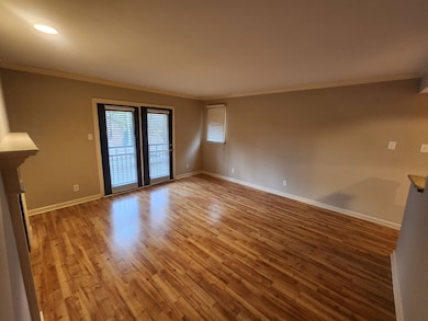 Unfurnished living room with crown molding, wood f