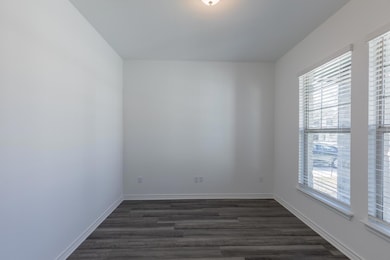 Empty room with baseboards and dark wood finished