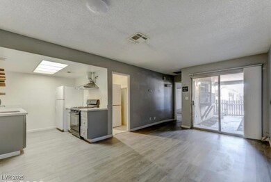 Kitchen featuring a textured ceiling, light wood-s