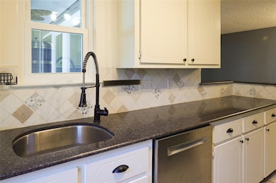 Kitchen featuring dishwasher, a sink, white cabin