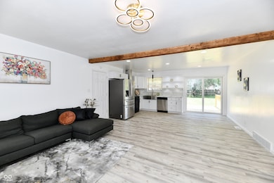 living area featuring light wood-type flooring, beam ceiling, and recessed lighting