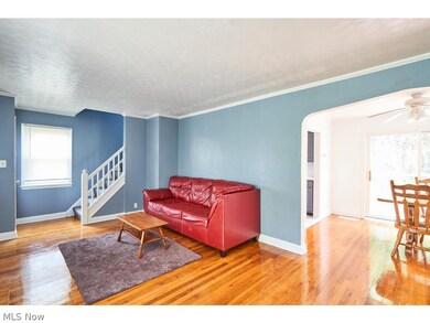 Living room with crown molding, a textured ceiling, wood-type flooring, and ceiling fan