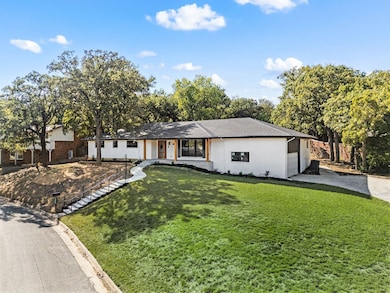 View of front of house with a front lawn, stucco siding, and a shingled roof