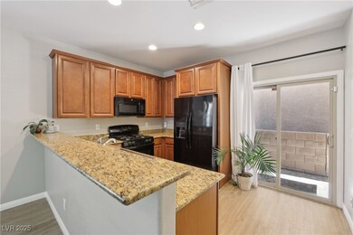Kitchen with black appliances, light wood-type flo