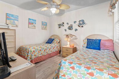 Bedroom featuring wood finished floors, ornamental molding, and a ceiling fan