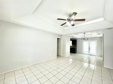 Tiled empty room featuring ceiling fan, french doors, and a tray ceiling
