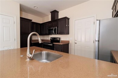 Kitchen with appliances with stainless steel finishes and light stone countertops