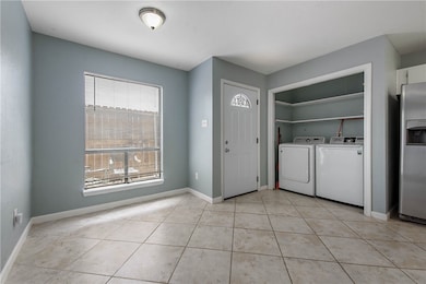 Laundry area with light tile patterned floors, sep