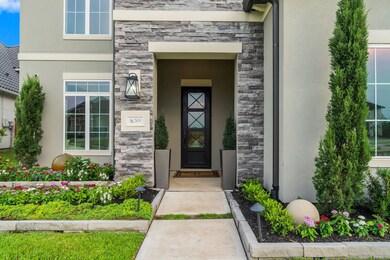 As you approach the front entrance, you are greeted with custom landscaping, lights, and fountain.