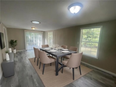 Dining room featuring baseboards, healthy amount of natural light, and wood finished floors