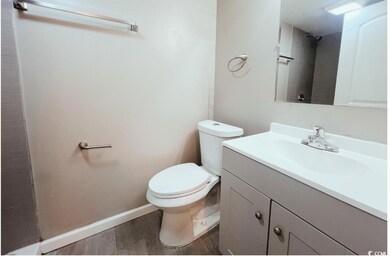Full bath featuring toilet, vanity, wood finished 