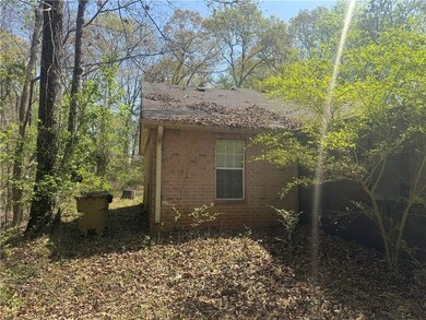 View of side of property featuring brick siding and roof with shingles