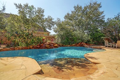 Private backyard with saltwater pool, hot tub, two rock waterfalls, extensive flagstone, and fire pit.