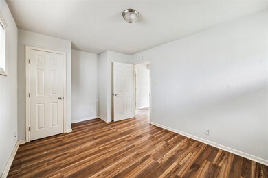 The primary bedroom has neutral paint, laminate fl